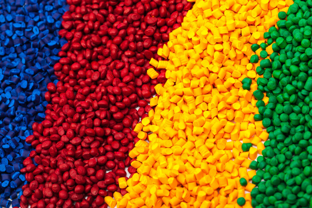 Image of plastic pellets being mixed with processing aids to improve material flow during production.