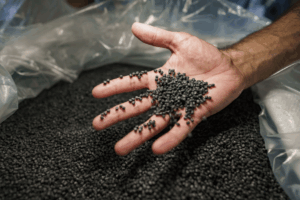 A person examines weather-resistant plastic additives that help protect materials from sunlight, moisture, and temperature changes.