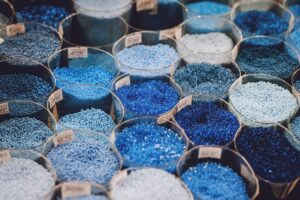 Colorful plastic additive beads used in plastic molding processes to enhance performance and durability.