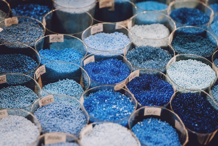Colorful plastic additive beads used in plastic molding processes to enhance performance and durability.