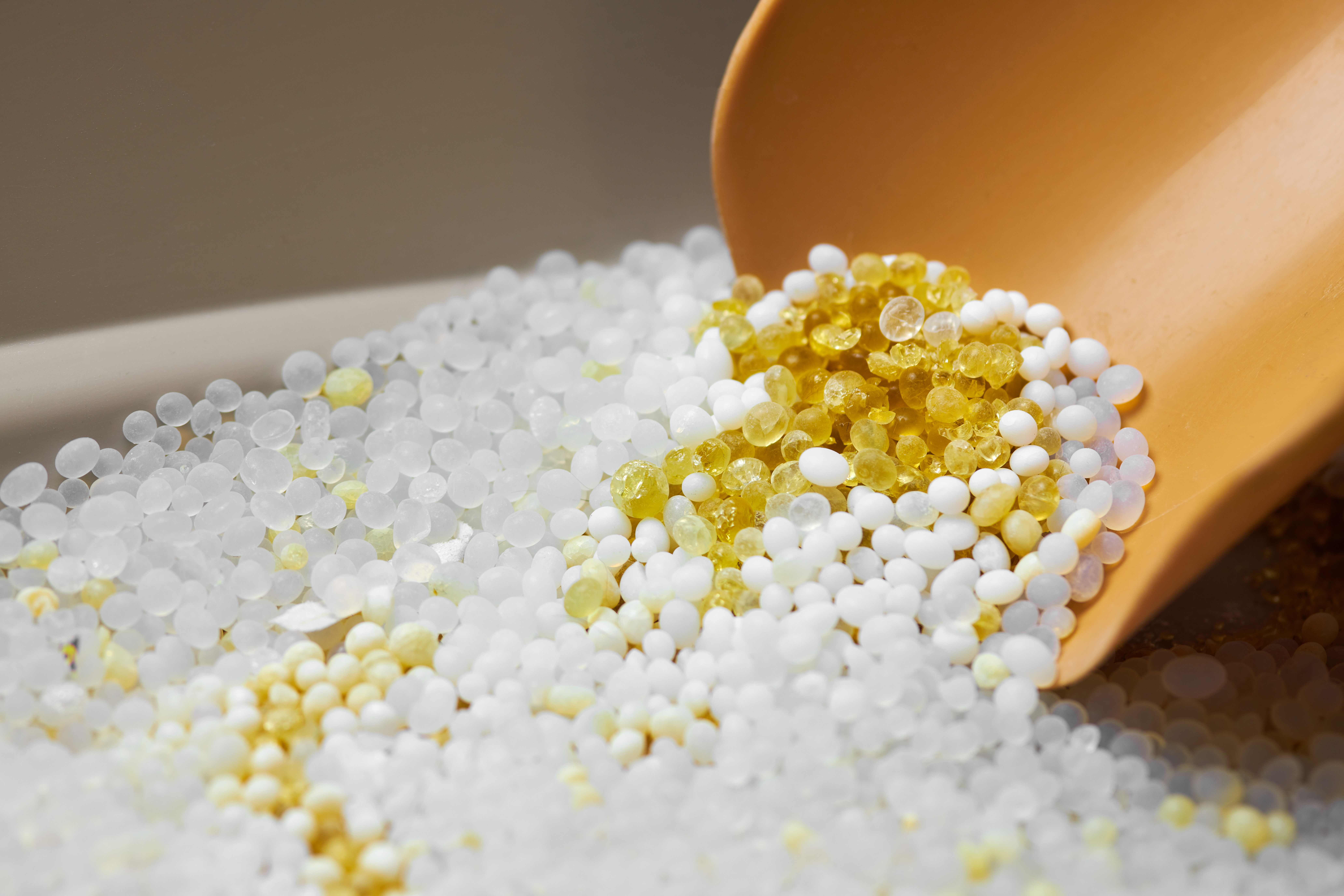 Plastic additive beads representing emerging plastic additive trends in modern manufacturing
